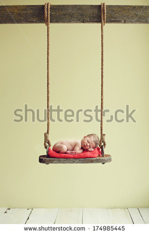 newborn-baby-boy-sleeping-on-an-antique-swing-174985445